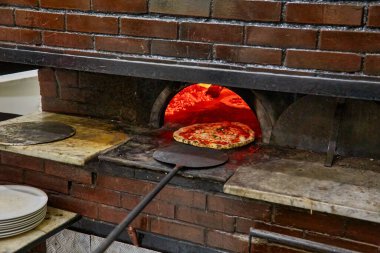 Napoli restoranında geleneksel ahşap fırında margherita pizza pişirdim. Orijinal Napoli pizzası. Kırmızı sıcak kömür.