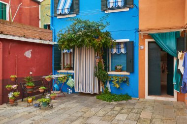 Blue facade of the house with door and windows. Colorful architecture in Burano, Italy.