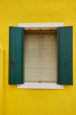 Evin sarı cephesinde kapı ve pencere var. Burano Adası, Venedik, İtalya 'da renkli mimari.