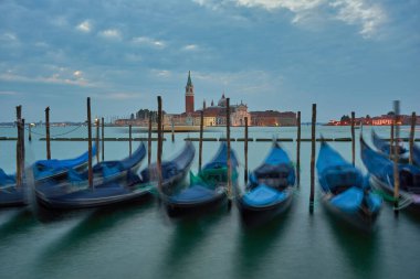 Venedik 'teki en popüler ve romantik yer. Gondollar St. Mark Meydanı 'nda demirlemişti. Arka planda San Giorgio di Maggiore Kilisesi vardı. Gün batımında Venedik, İtalya..