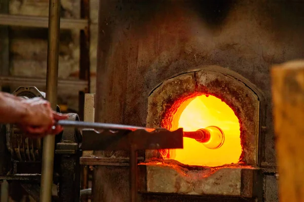 穆拉诺玻璃吹工厂 形成漂亮玻璃片的鼓风机 将带有玻璃附着物的铁棒放在炉膛中 使玻璃具有可塑性 意大利威尼斯 — 图库照片