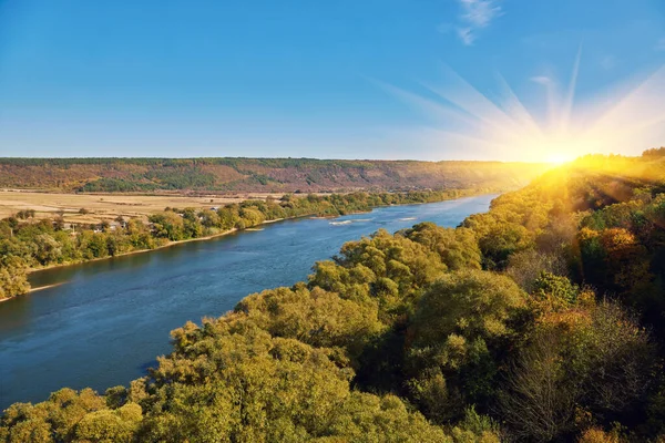 stock image a wide river in the autumn season, forest trees with yellowed foliage on the riverbank in autumn