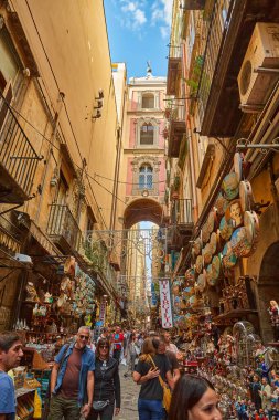 Napoli, İtalya - 25 Ekim 2019 - Şehir sakinleri tarihi Centro Storico şehir merkezinin dar çamaşırhaneli caddesinde park halindeki araçlar arasında yürürler..