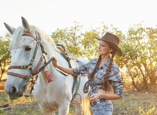 戴着帽子抱着马的快乐的女牛仔 — 图库照片