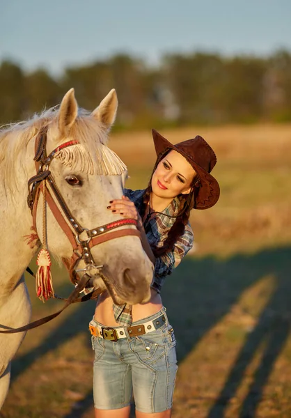 帽子立っていると彼女の馬を抱いて幸せな美しい若い女の騎乗位 — ストック写真