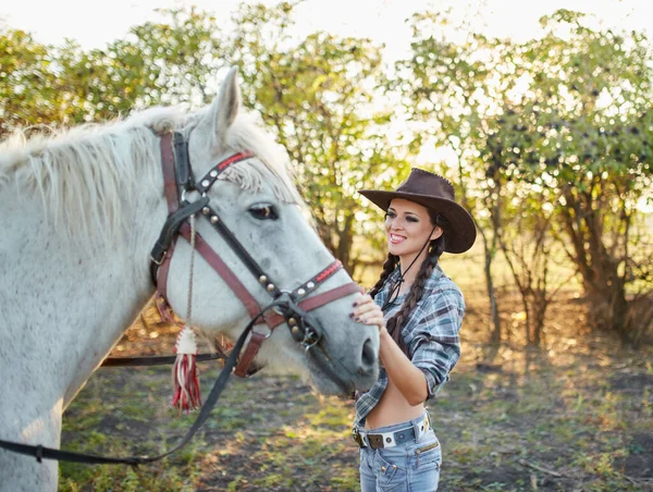 戴着帽子抱着马的快乐的女牛仔 — 图库照片