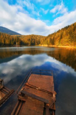 Lake in mystery fog with autumn forest. Ghostly mountain lake. Ukrainian lake Synevir