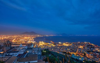 Napoli, İtalya. Napoli Körfezi 'nin üzerinde gün batımının güzel ışıkları ön planda marina ve arka planda Vezüv Dağı var..