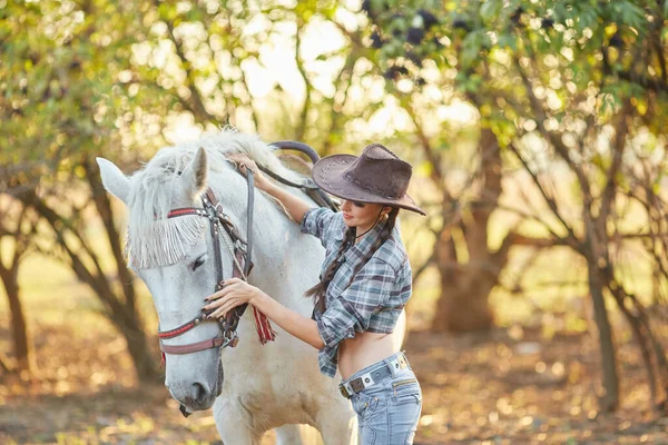 Portrait of young cowgirl and horse outdoors