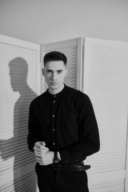 Parlak bir arka planda genç bir adamın portresi. Siyah beyaz fotoğraf