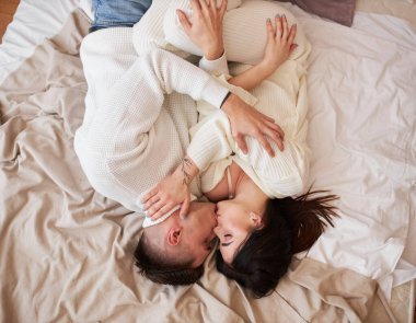 Gülümseyen sevimli kız arkadaşı, erkek arkadaşıyla olmaktan ve birbirleriyle iletişim kurmaktan mutlu. Olumlu romantik çift, kış tatili boyunca rahat bir şekilde yataklarında dinleniyor.