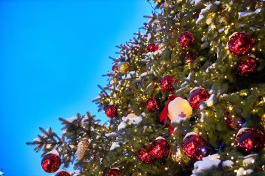 Gece sokakta kırmızı balonlu Noel ağacı