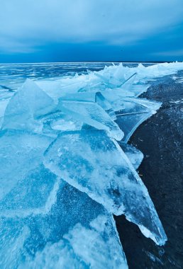 Karla kaplı el değmemiş, buz mavisi bir göl içeren sakin bir kış sahnesi. Doğanın sakin güzelliği kışın ortasında yakalanır..