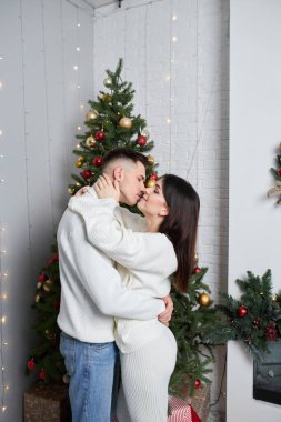 Köknar yakınında duruyor. Genç romantik çift yeni yılı içeride kutluyor..