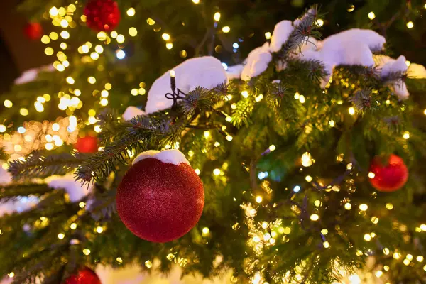 Gece sokakta kırmızı balonlu Noel ağacı