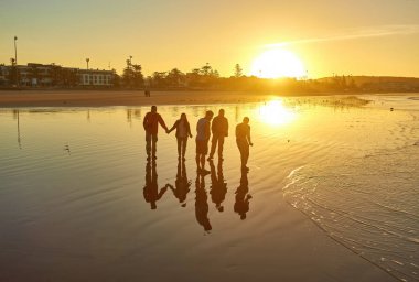 Turistler Essaouira 'nın Atlantik sahilinde şafağın esansını yakalıyorlar, siluet anılarını sabahın erken saatlerinde gökyüzüne karşı çekiyorlar..
