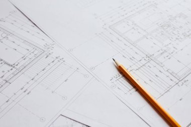 İnşaat endüstrisinin planı üzerine yazmak için kalem ve ofis aletleri. Ekmekleri inşaat endüstrisi geçmişinin bulanık planının üzerine koy. İnşaat endüstrisi konsepti.