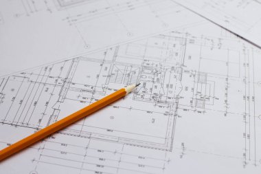 İnşaat endüstrisinin planı üzerine yazmak için kalem ve ofis aletleri. Ekmekleri inşaat endüstrisi geçmişinin bulanık planının üzerine koy. İnşaat endüstrisi konsepti.