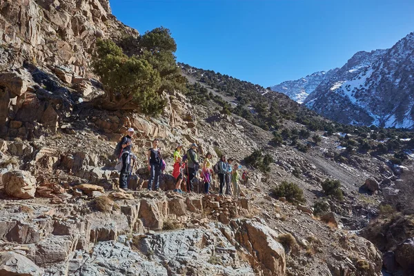 A group of tourists trekking through the stunning Atlas Mountains in Morocco, embracing the beauty of the rugged terrain and connecting with nature