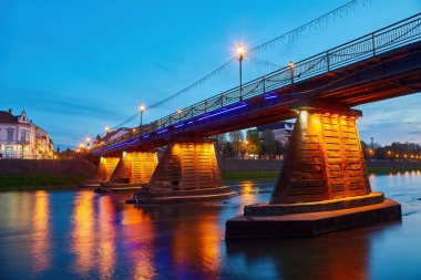 Illuminated pedestrian bridge in the center of Uzhgorod in the evening,