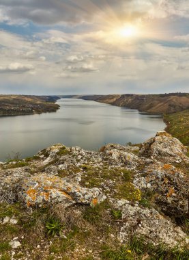 Büyük bir nehrin kıyısında. Bakota, Dinyester Nehri, Ukrayna. Pürüzsüz sakin su panoramik manzarası. Yüksek bankalar, yeşil tepeler. Doğu Avrupa 'da yaz günü.