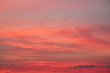 Gün batımında gökyüzünün büyüleyici bir görüntüsü, canlı renkler bulutları boyuyor. Doğanın dansı başlıyor, bulutlar zarif bir şekilde akşam ışığında hareket ediyor.