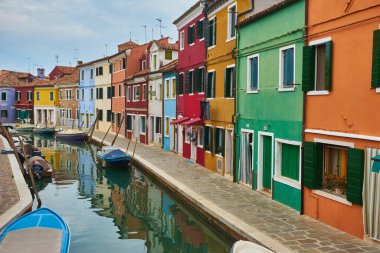 Burano adası, renkli binalar arasında dar kaldırım taşı caddesi çok renkli duvarlar, mavi gökyüzü güneşli yaz günü, Venedik Eyaleti, Veneto Bölgesi, Kuzey İtalya. Burano kartpostalı