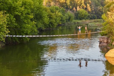 Çürük bir ahşap asma köprü, sakin bir sabahta bir nehir boyunca uzanıyor ve iki genç çocuğun nehrin karşısına geçtiği görülüyor. Nehir, yemyeşil suları yansıtan huzur içinde akar. Bu cennet sahnesi Chil 'in özünü yakalıyor.