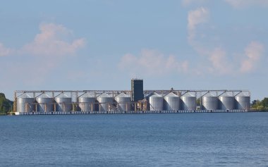 Nehirde bir tahıl asansörü deposu, yaz günü.