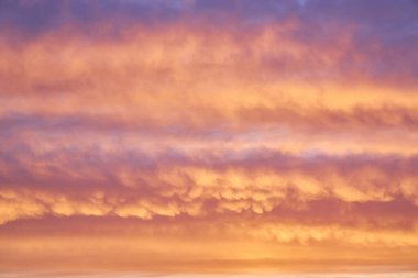 Gökyüzünün büyüleyici bir parçası, batan güneş tarafından aydınlatılan çok renkli bulutların yer aldığı doğal bir zemin, nefes kesen renk ve desenlerden oluşan bir tuval yaratıyor.