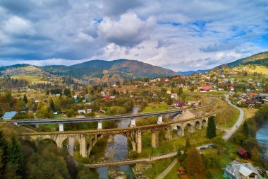 İHA 'dan hava görüntüsü. Viaduct üzerindeki hava manzarası inanılmaz Vorokhta Ukrayna 'daki bir Avusturya taş kemer köprüsü. Karpat Dağları 'nda bulutlu bir sonbahar günü