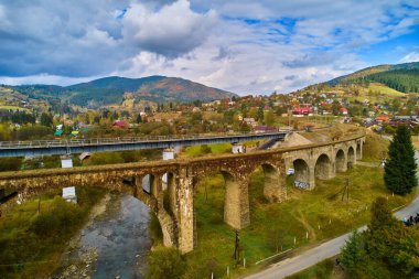 İHA 'dan hava görüntüsü. Viaduct üzerindeki hava manzarası inanılmaz Vorokhta Ukrayna 'daki bir Avusturya taş kemer köprüsü. Karpat Dağları 'nda bulutlu bir sonbahar günü