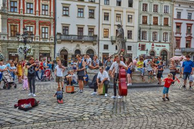 Lviv, Ukrayna - 13 Ağustos 2019: İnsanlar Lviv'in merkezindeki Rynok Meydanı'ndaki Neptün Çeşmesi yakınlarında dinleniyor