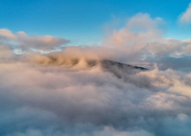 Sis şafakta dağların üzerine yayılır. Güneş ufuktan doğuyor. Sabah Ukraynalı Karpatlar. Hava aracı görünümü.