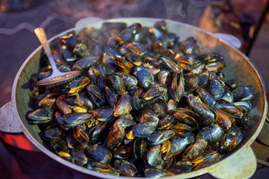 Sokak yemeği. Bir sokak fuarında haşlanmış midye ve otlar..