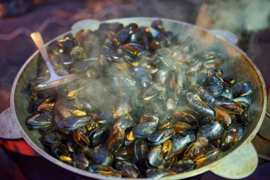 Sokak yemeği. Bir sokak fuarında haşlanmış midye ve otlar..