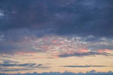 A mesmerizing fragment of the sky, a natural backdrop featuring multicolored clouds with intriguing shapes illuminated by the setting sun, creating a breathtaking canvas of hues and patterns clipart