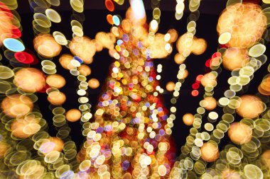 Blurred christmas tree with lights decorations outdoors at night. New Year Celebration. clipart