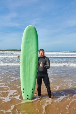 A young surfer strikes a pose with his board on the oceanfront in Essaouira, capturing the essence of surf culture against the picturesque backdrop of the Atlantic clipart