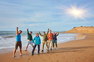 Bir grup turist, Fas, Essaouira sahillerinde ortak bir fotoğraf çekiyor. Bir grup turist, Fas 'ın Essaouira kentindeki Atlantik Okyanusu kıyılarında şafağın dinginliğini yakalıyor..