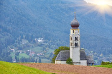 St. Valentin Kastelruth Village Church in the summer in the Dolomite Alps. Amazing landscape with small chapel on sunny meadow and Petz peak at Kastelruth commune. Dolomites, South Tyrol, Italy