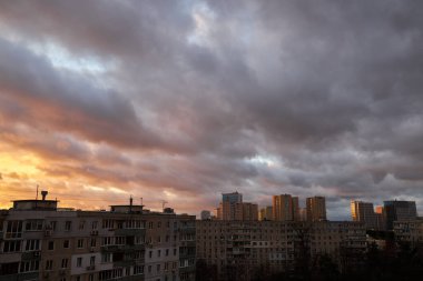 Göz kamaştırıcı bir gün batımı gökyüzü uzak bir şehrin silueti üzerinde pembe, turuncu ve mavi bulutlarla dolu. Canlı renkler ve yumuşak ışık huzurlu ve dinamik bir şehir atmosferi yaratır..