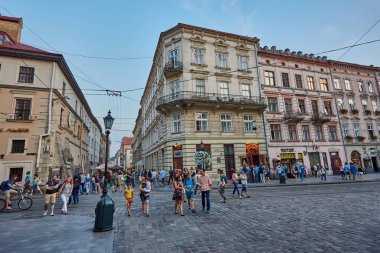 Lviv, Ukrayna - 13 Ağustos 2019: İnsanlar Lviv'in merkezindeki Rynok Meydanı'ndaki Neptün Çeşmesi yakınlarında dinleniyor