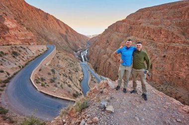 Fas 'ın güneyindeki Dades Vadisi' nde kayalık bir duvarı gözlemleyen yürüyüşçüler.