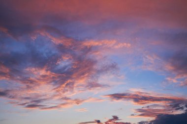 Yumuşak pembe, mor ve mavi renklerle dolu güzel bir günbatımı gökyüzü. Bulutlar batan güneş tarafından aydınlatılır. Huzurlu ve sakin bir atmosfer yaratır. Arkaplan ve tasarımlar için idealdir..