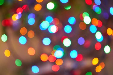 Çeşitli renklerdeki şenlikli bokeh ışıkları canlı ve neşeli bir arka plan yaratır. Görüntü, yeşil, kırmızı, mavi, turuncu ve beyaz tonlarda bulanık dairesel şekiller içererek neşeli bir tatil atmosferini çağrıştırıyor..