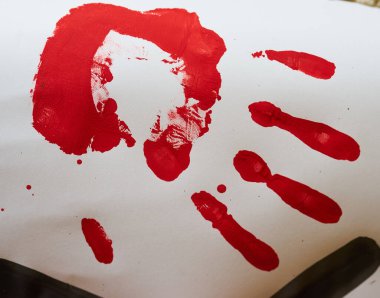 Beyaz bir yüzeyde kırmızı bir el izi, şiddeti, kan dökülmesini ve çatışmanın kalıcı etkisini simgeliyor..