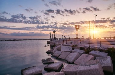 Bari sahil. Renkli muhteşem gün batımı. Kıyı şeridi ve şehir görüntüleyin. Alacakaranlık mor ve mavi gökyüzü.