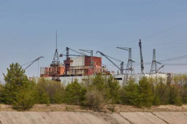 Ukrayna 'nın Çernobil Yasak Bölgesi' nde vinç ve elektrik kuleleri bulunan kısmen inşa edilmiş ve terk edilmiş reaktör binaları.