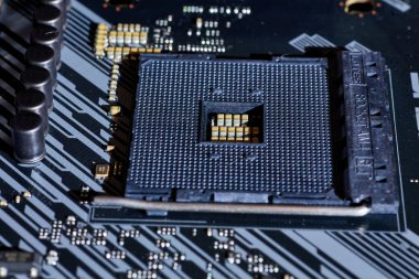 Ana karttaki boş bir işlemci soketinin detaylı bir görüntüsü, bağlantı noktaları ve çevresindeki elektronik bileşenlerin karmaşık şebekesini vurguluyor. Teknolojiyle ilgili projelerde veya geçmişlerde kullanmak için ideal.